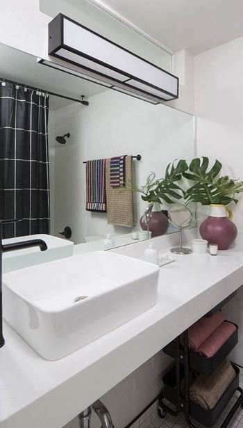 a white bathroom with a sink and a mirror at The Flat, Los Angeles, CA